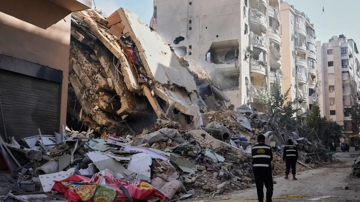Myanmar Military Airstrike on Buddhist Monastery Kills 14, Injures 20 in Sagaing Hezbollah members walk past a building destroyed by an Israeli airstrike in Dahiyeh, Beirut's southern suburbs, Lebanon, Thursday, March 5, 2026.
