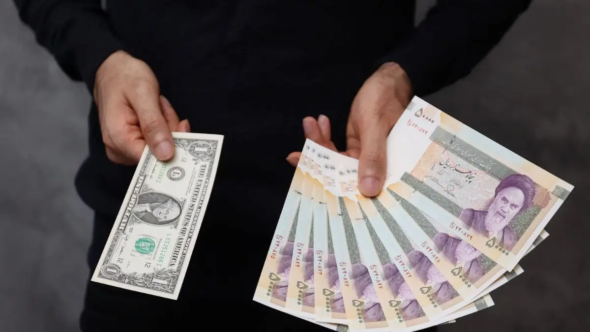 Economic Crisis Deepens: Iran's Rial Crashes to 1.8 Million Per US Dollar as Ceasefire Totters Iranian rial banknotes and US dollar bills on a digital exchange rate chart showing a downward trend.