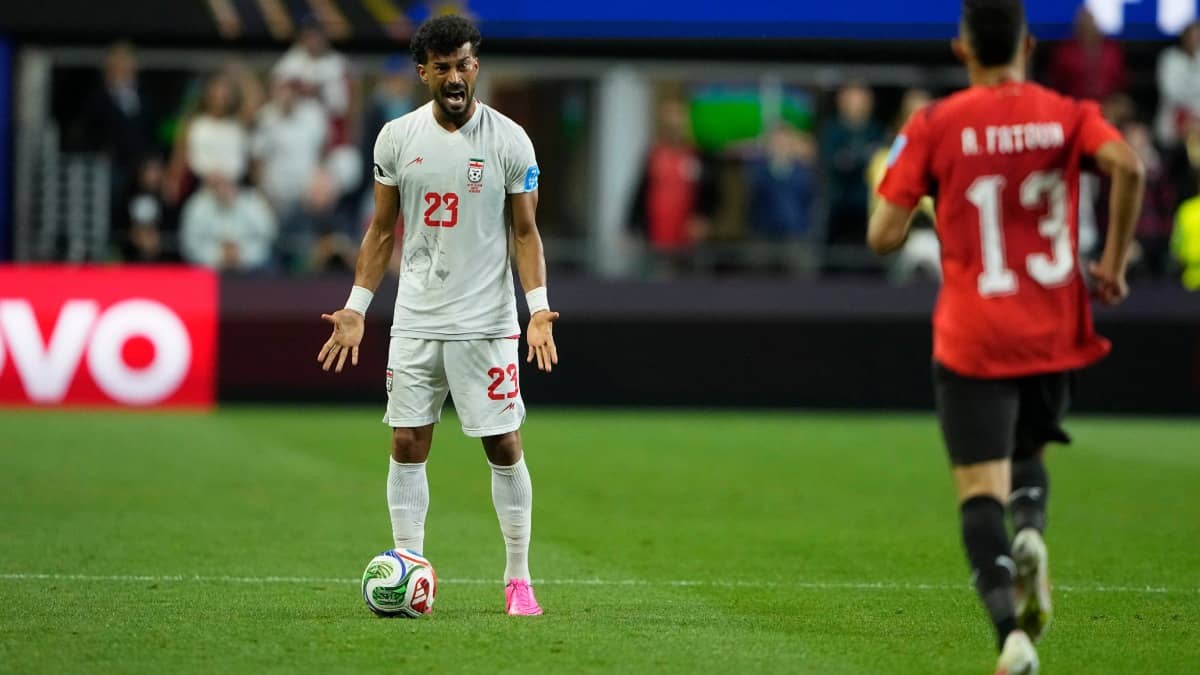 Iran defender Ramin Rezaeian reacts during a match