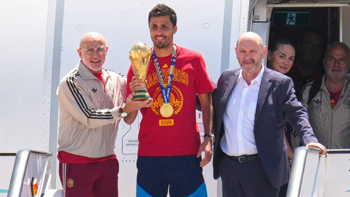 Rodri and coach Luis de la Fuente pose with the WC trophy