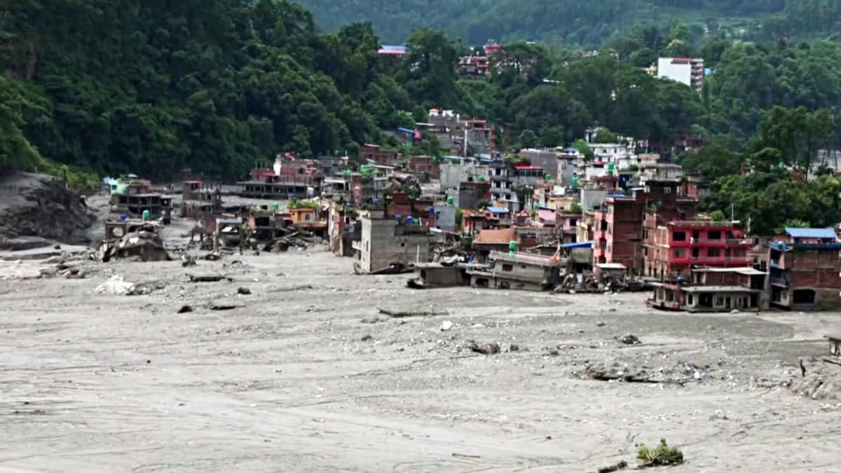 A drone view of the buildings damaged and surrounded by thick mud and debris along the Trishuli River following flash floods