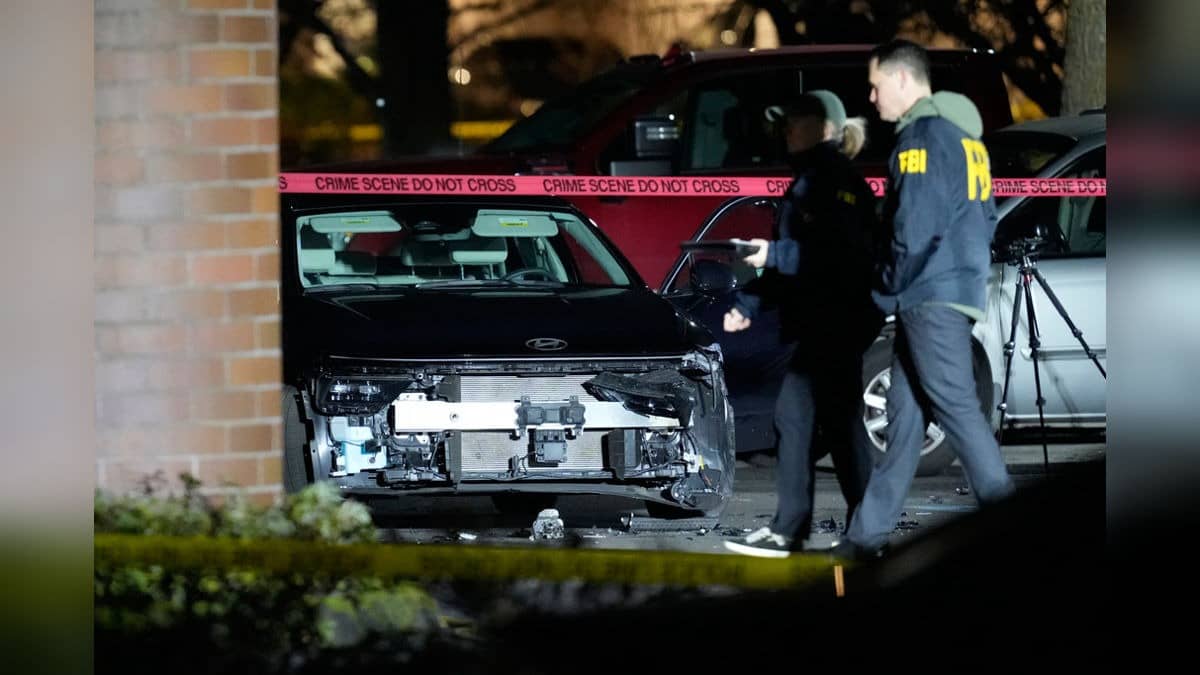 A damaged car is seen as law enforcement officials work the scene following reports that federal immigration officers shot and wounded people in Portland