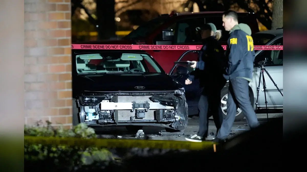 A damaged car is seen as law enforcement officials work the scene following reports that federal immigration officers shot and wounded people in Portland