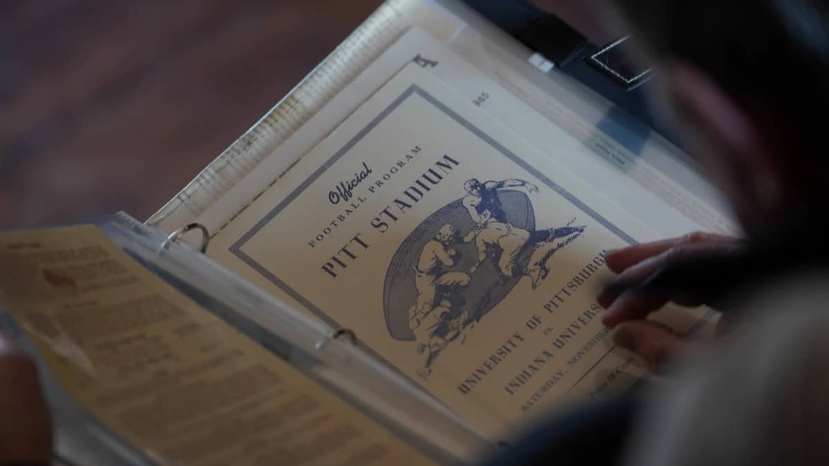 A vintage sports program sits in a photo album