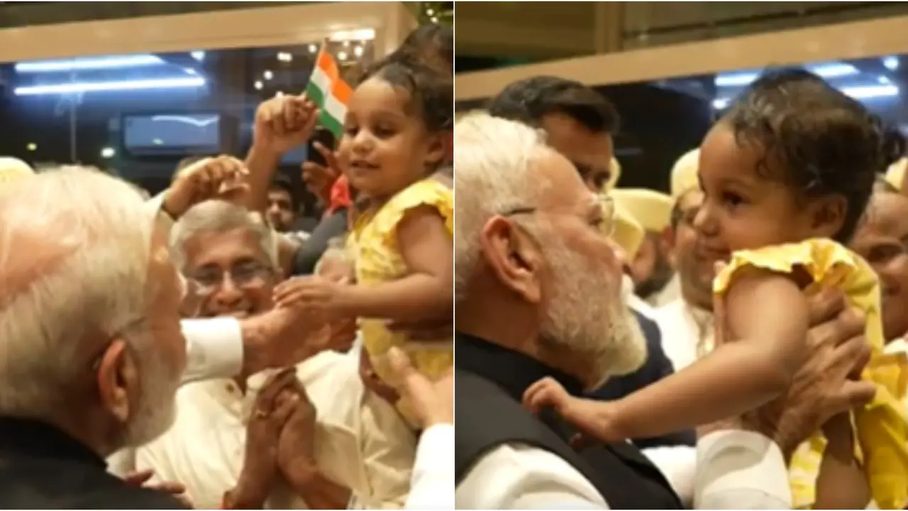 The video shows PM Modi warmly lifting the toddler in his arms.