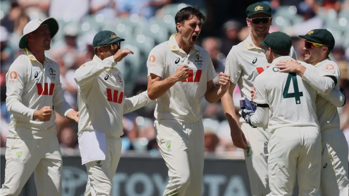 Australia's Pat Cummins, centre, celebrates with teammates after taking the wicket of England's Joe Root in Adelaide Test