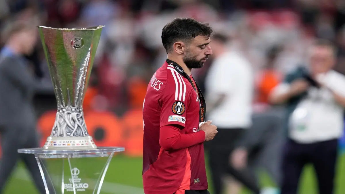 Bruno Fernandes walks past the Europa League trophy