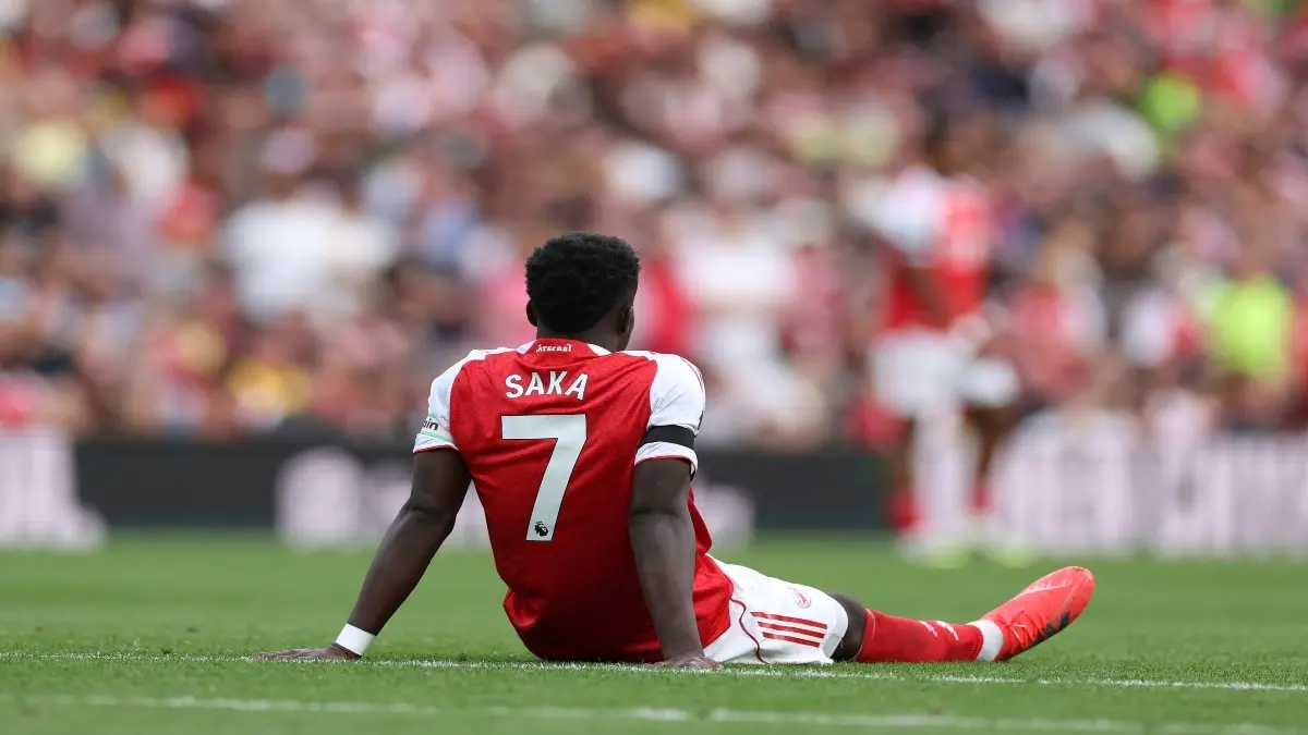Bukayo Saka sits on the groun after an injury