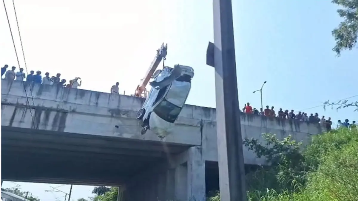 Miracle Escape in Delhi: Car Falls Off Flyover Onto Railway Tracks, Driver Survives With Minor Injuries Car wreck on Delhi railway tracks after falling from flyover, police inspecting site