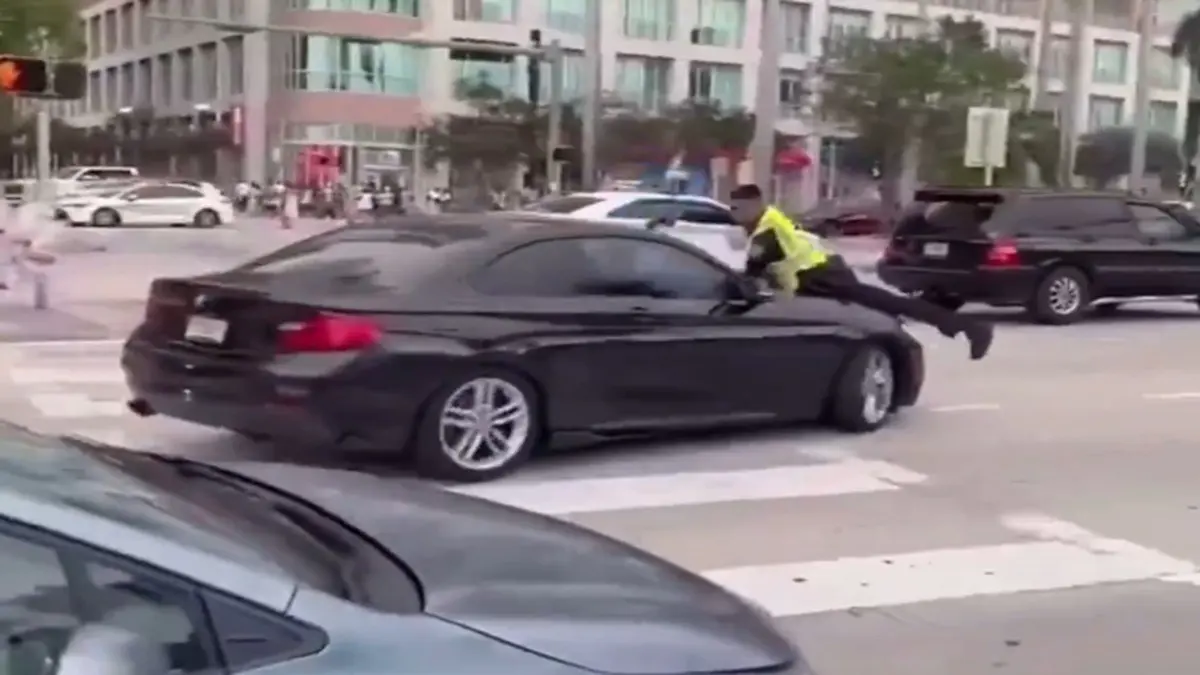 Miami Police Shooting Caught On Camera: Cop Fires Multiple Times At Driver After Clinging To Car Disturbing Video Shows Miami Cop Clinging To Car Hood Before Shooting Driver Multiple Times
