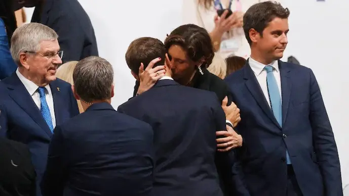 French Sports Minister Amelie Oudea-Castera kissing Emannuel Macron.