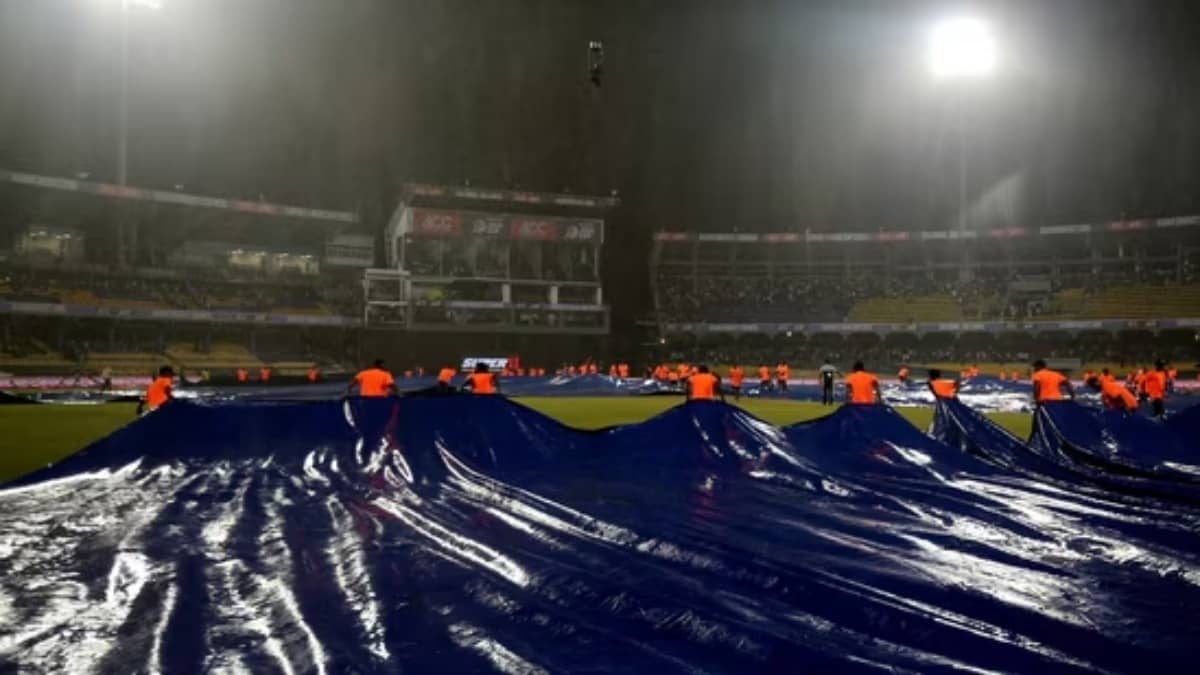 Ground staff come up with covers as rain stops play at the R. Premadasa