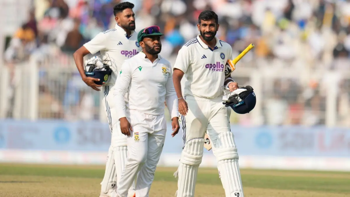 India's Jasprit Bumrah and Mohammed Siraj leave the field with South Africa's captain Temba Bavuma at the end of the Kolkata Test