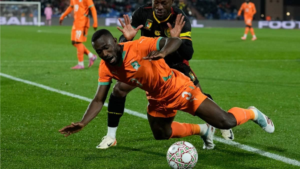 Ivory Coast's Ghislain Konan is challenged by Cameroon's Christian Bassogog during the AFCON group F fixture
