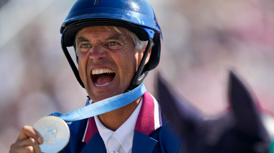 Karim Laghouag of France celebrates after winning the silver medal in the equestrian team jumping competition at the 2024 Summer Olympics