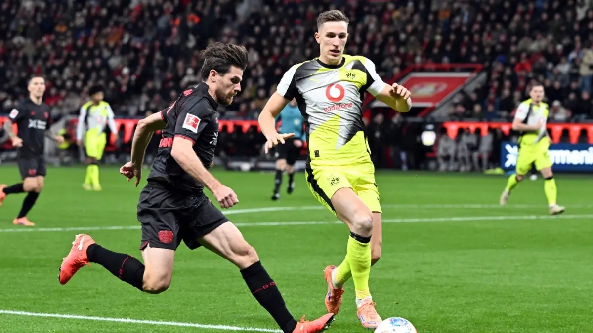 Leverkusen's Jonas Hofmann, and Dortmund's Nico Schlotterbeck in action
