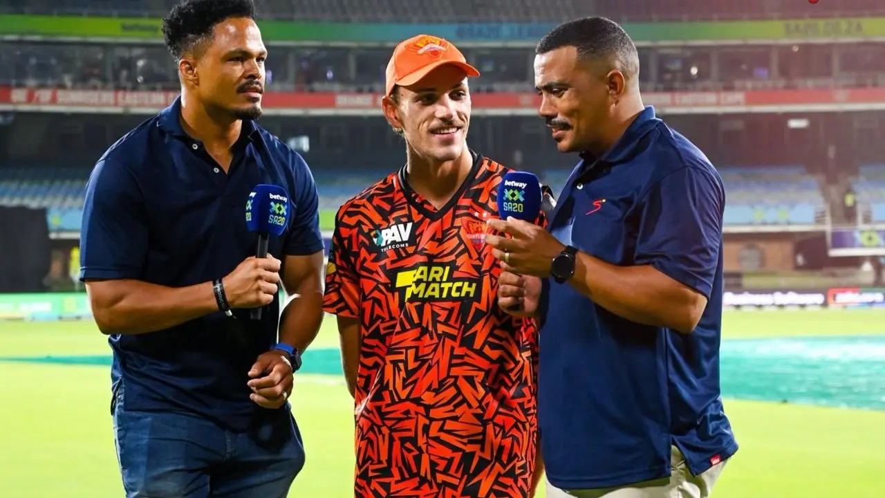 Marco Jansen in conversation with presenters standing on chair