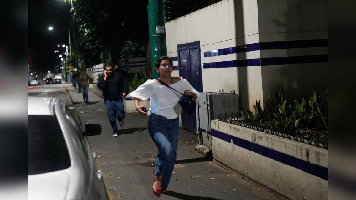 Pedestrians run after explosions and low-flying aircraft were heard in Caracas, Venezuela, Saturday.