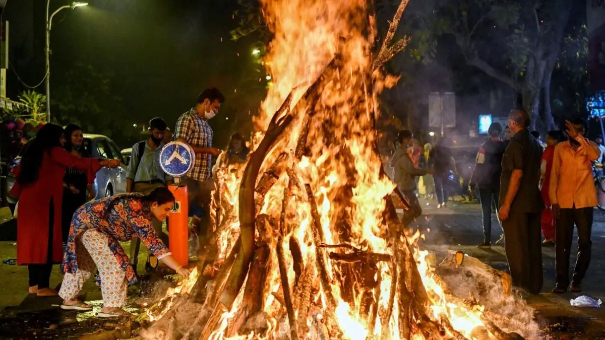 Holika Dahan 2026: Wishes, Greetings, Whatsapp Messages To Share With Loved Ones On The Pre-holi Festivity People celebrating Happy Holi 2026 with colorful gulal and water during spring festival in India