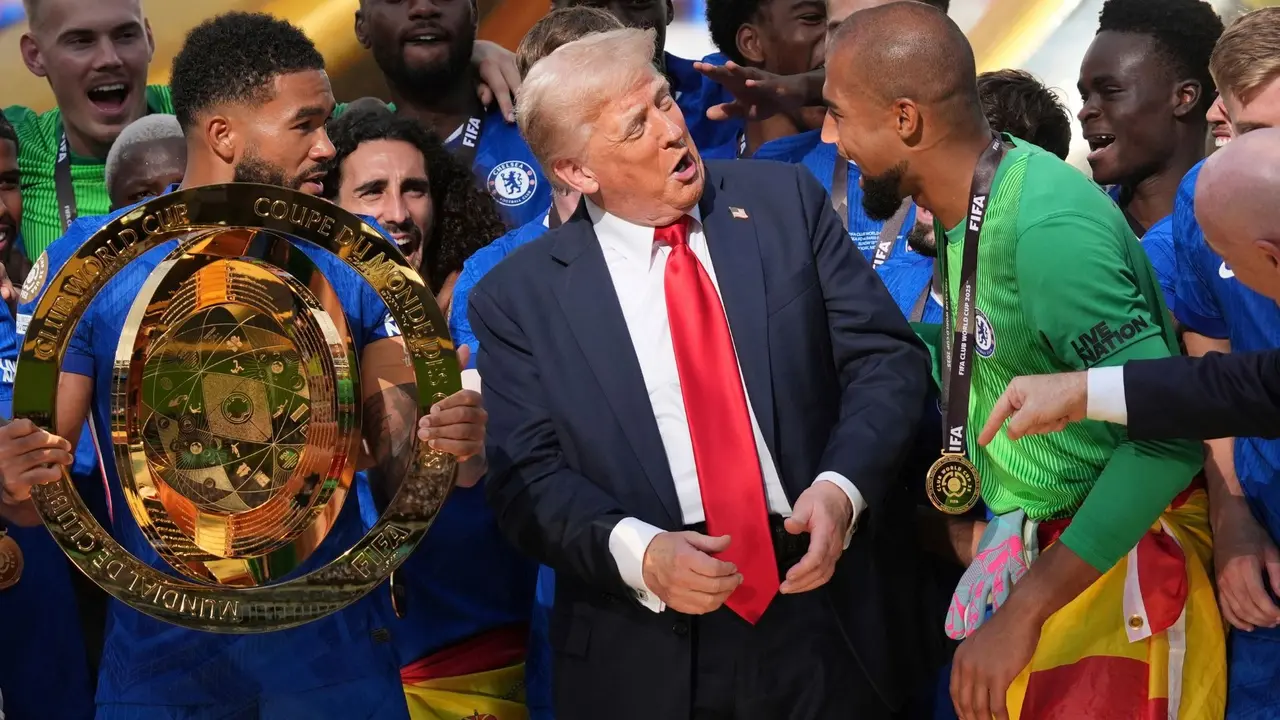 President Donald Trump speaks with Chelsea's goalkeeper Robert Sanchez (R) as Chelsea's Reece James holds the championship trophy following the Club World Cup final.