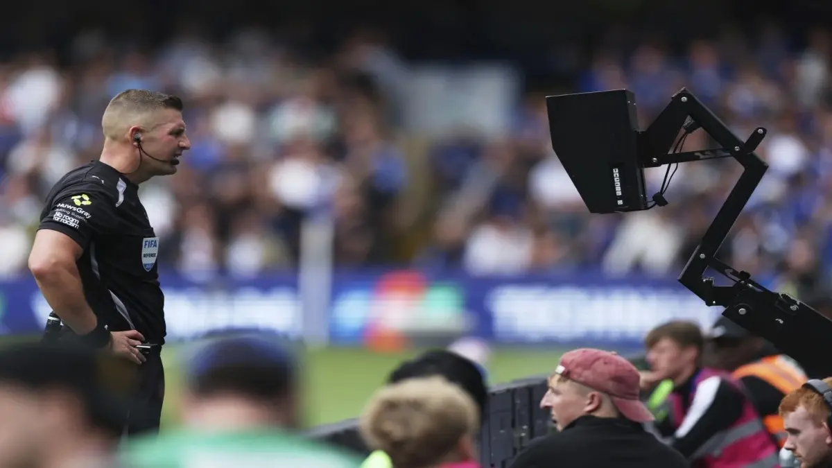 Referee Robert Jones checks the pitch side monitor