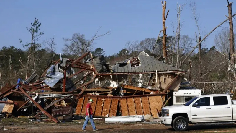 Residents look for personal belongings in the damage after a tornado passed through where two people lost their lives
