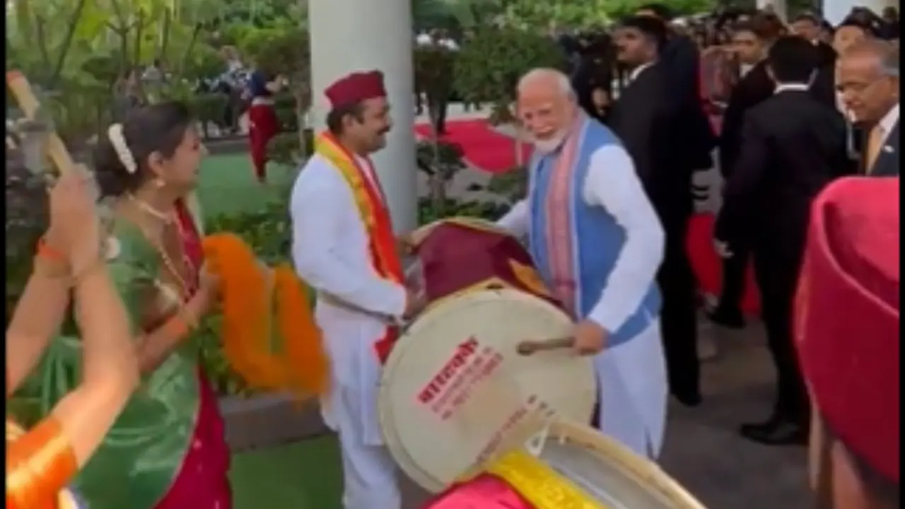 Video: PM Modi Flaunts His Dhol Skills, Shares Light Moments With Indian Diaspora in Singapore Screengrab from Video Shows PM Modi Playing Dhol at Singapore Airport