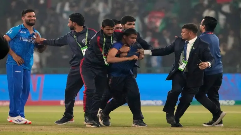Security officials escorting a pitch invader