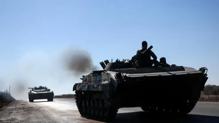 Around 4,000 Syrian Troops Crossed Border Into Iraq To Seek Refuge: Officials Syrian opposition fighters drive a seized Syrian army armored vehicle near the town of Khan Assubul, Syria, southwest of Aleppo