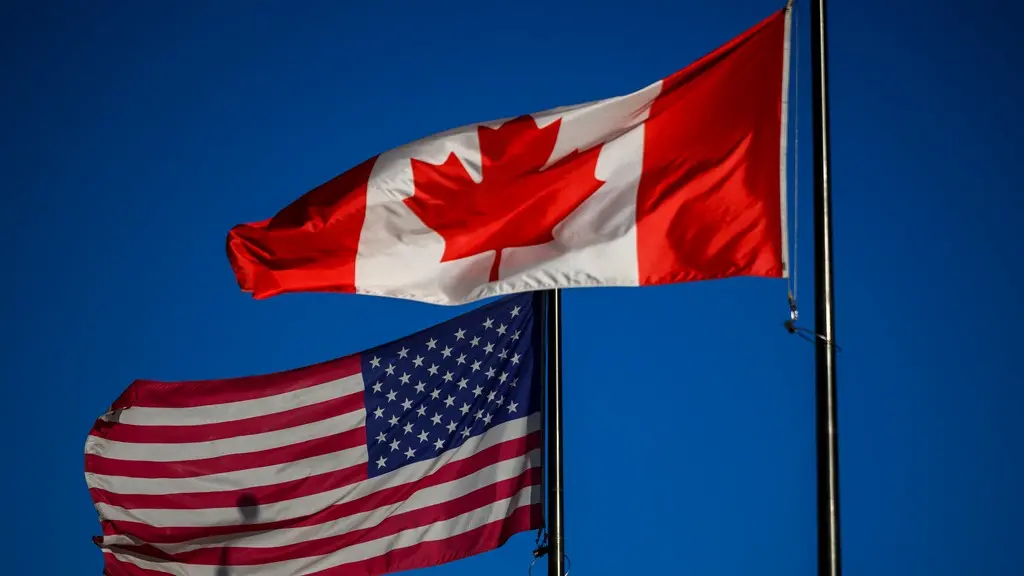 The flags of Canada and the United States fly outside a hotel in downtown Ottawa
