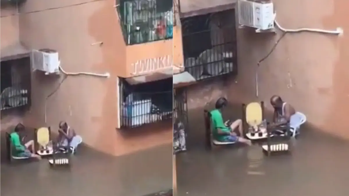Two men enjoying alcohol drinks in knee-deep water in Mumbai