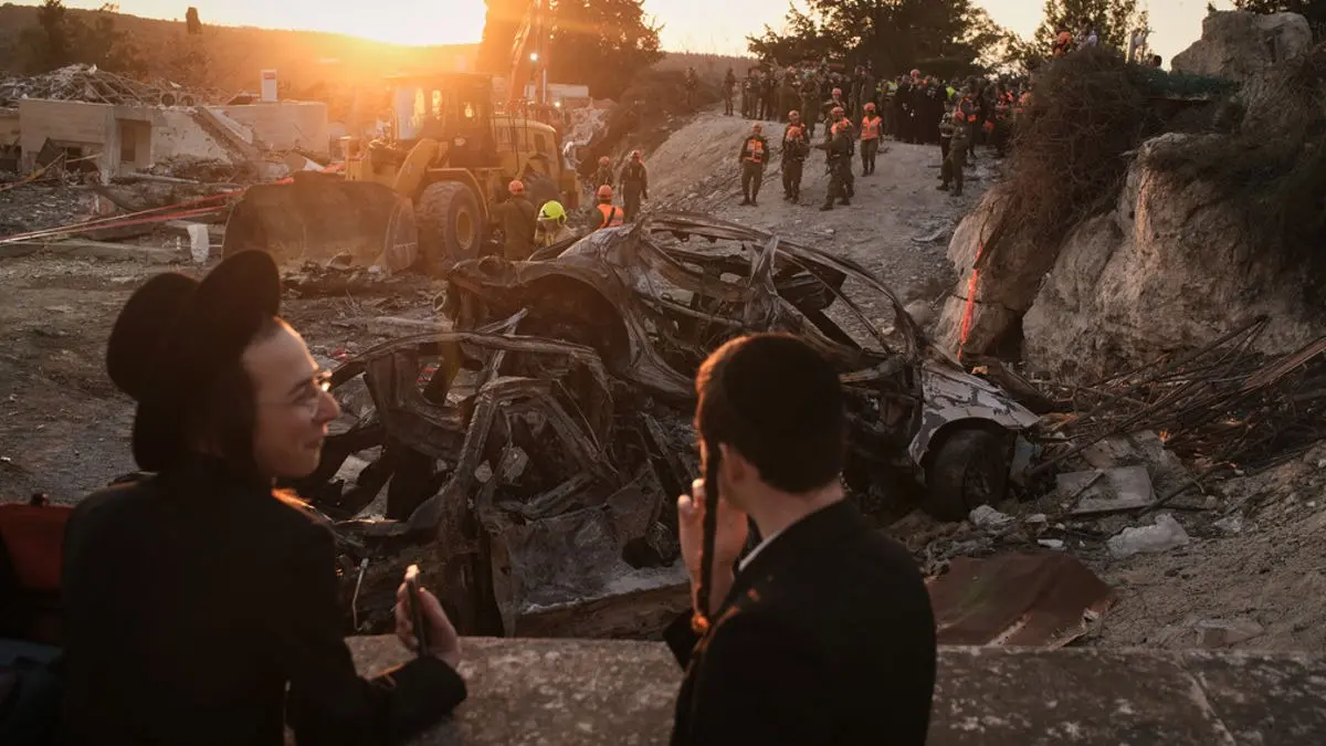 Images Show Aftermath In Israel As Iran Retaliates With Missiles; Rescue Teams, Damage & Tensions Captured | Take A Look Ultra-Orthodox Jewish men look on as Israeli security forces operate at the site where several people were killed in an Iranian missile strike in Beit Shemesh, Israel, Sunday, March 1, 2026. (AP Photo/Leo Correa)