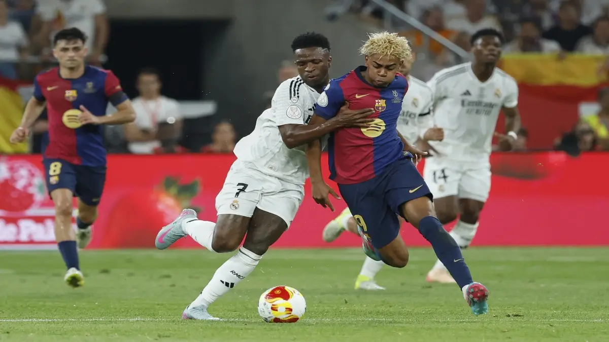 Vinicius Jr is vying for a ball with Lamine Yamal