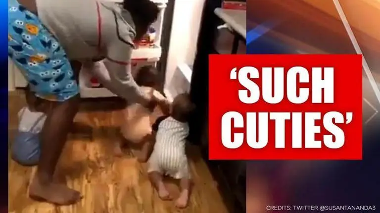 Father struggles to keep toddler triplets away from fridge, video melts hearts Father struggles