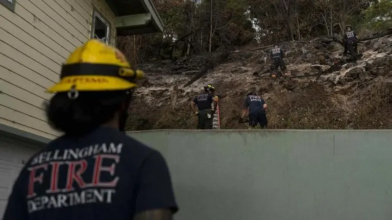 Firefighters clear debris (Image: AP)