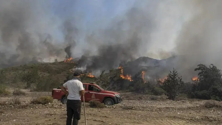 Tourist hotspot Island of Rhodes continues to burn as successive deadly heat waves ravage Greece A man watches the fire burning a forest in Vati village, on the Aegean Sea island of Rhodes,