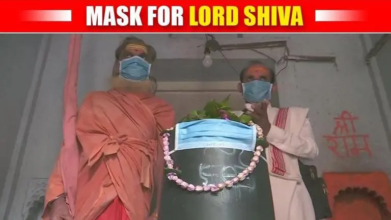 Devotees and Priests cover the Shiva Lingam with a mask in Varanasi Devotees