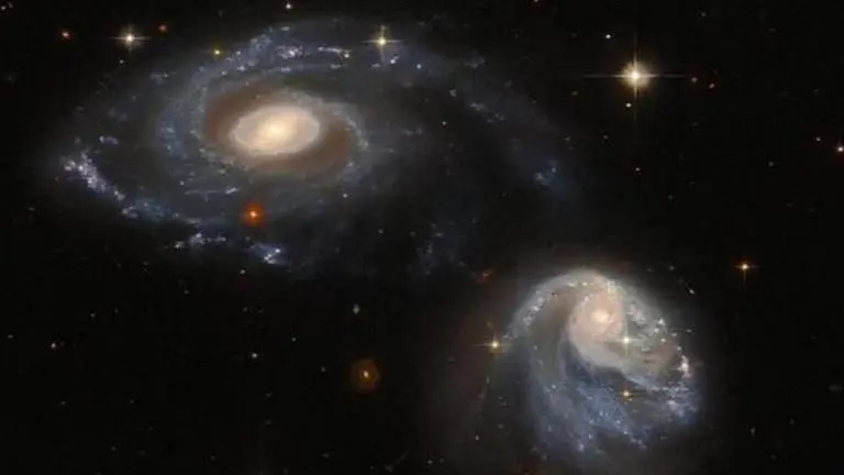 Hubble telescope photographs two spiral galaxies gravitationally distorting one another Hubble Telescope