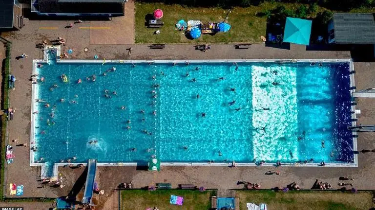 Germany's public heath chief proposes afternoon naps & cold foot baths amid rising heat Germany public pool heat