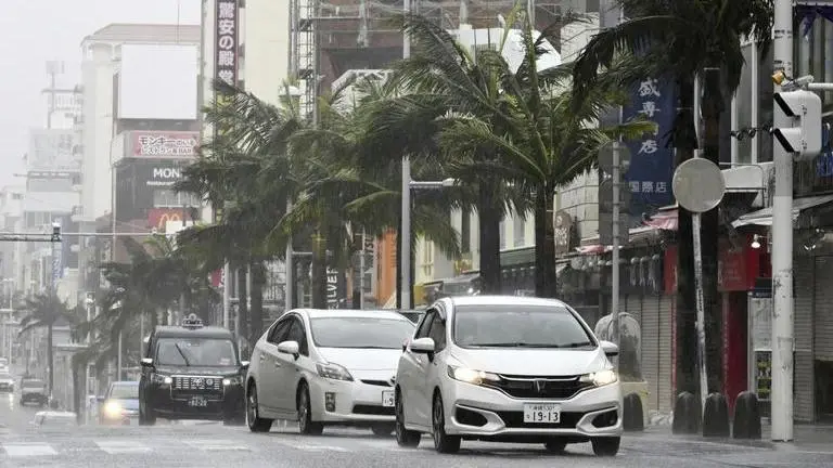 Vehicles drive through a street in a strong wind in Naha, Okinawa prefecture, southern Japan