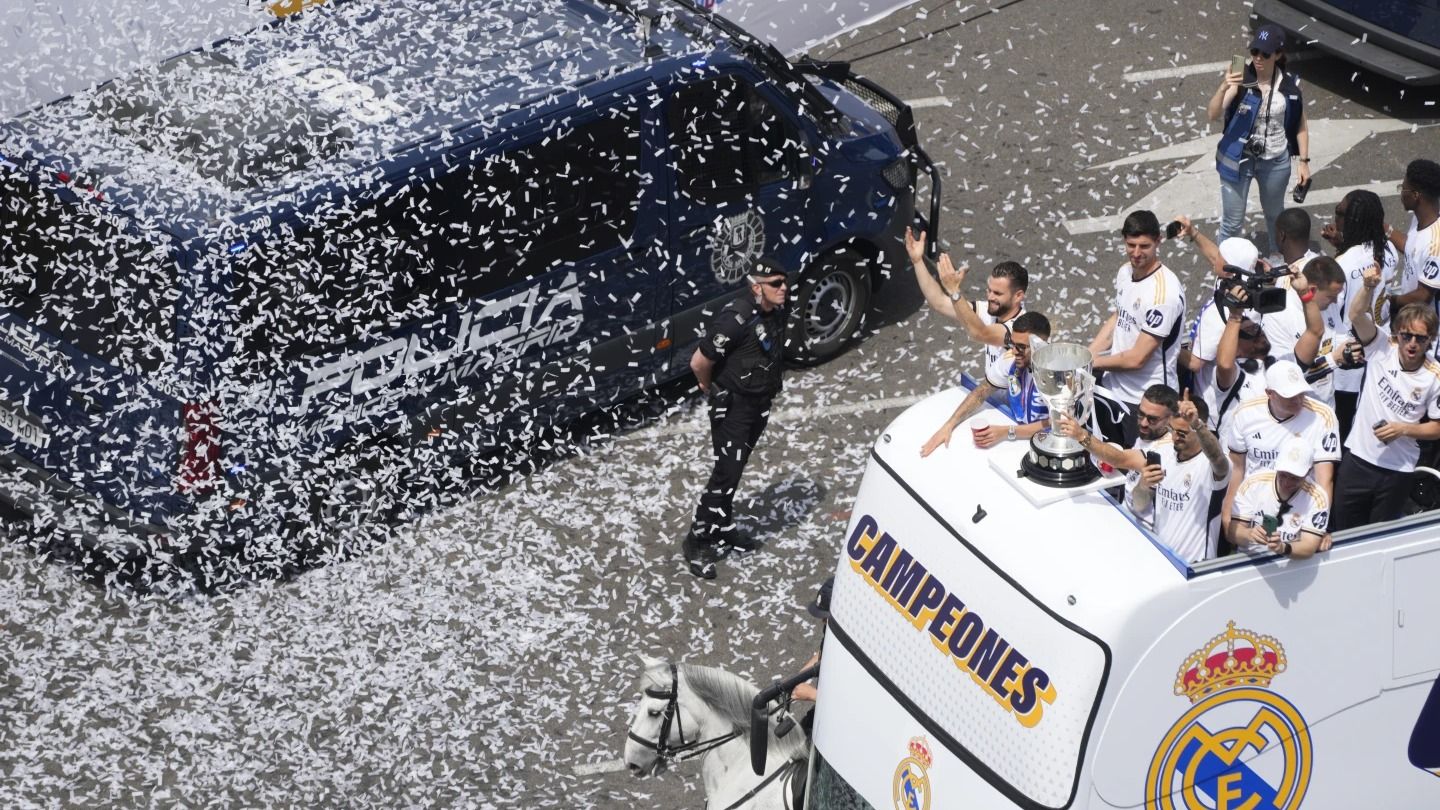 Real Madrid players soaked in the Confetti at the top of their open bus parade