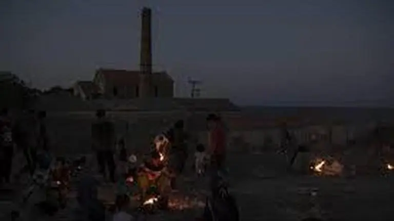 Migrants displaced by Moria fires wait by roadside