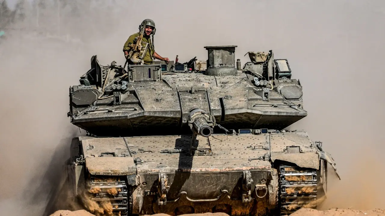 Israeli soldiers drive a tank at a staging ground near the border with the Gaza Strip, in southern Israel, Sunday, May 5, 2024.