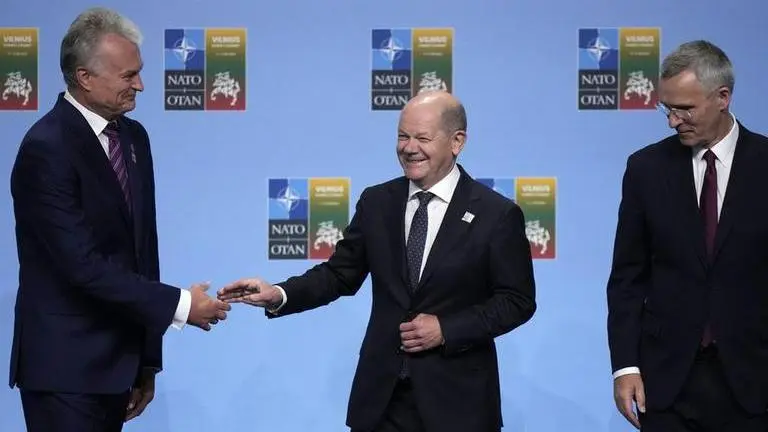 Lithuania's President Gitanas Nauseda, left, and NATO Secretary General Jens Stoltenberg, right, greets Germany's Chancellor Olaf Scholz