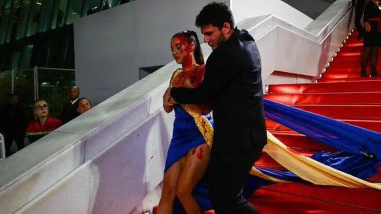 Woman in Ukrainian colours covers herself in fake blood on Cannes red carpet | Watch cannes 2023