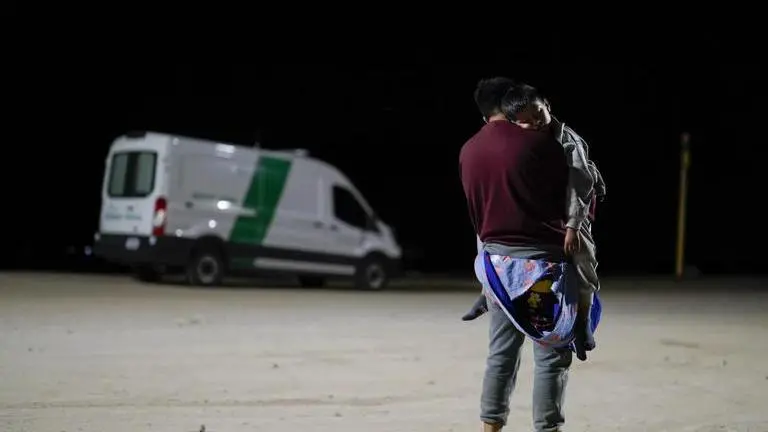 As illegal immigration drop, the legal challenges over Biden’s US-Mexico border policies grow A man from Colombia holds his son as he waits to apply for asylum after crossing the border from Mexico