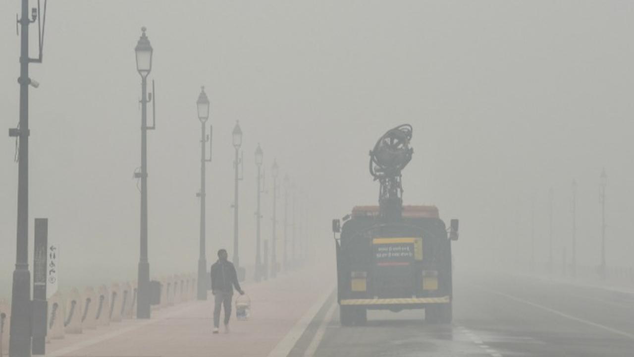 A truck-mounted water sprinkler sprays tiny droplets of water in an effort to mitigate the effects of air pollution at Kartavya Path in Delhi