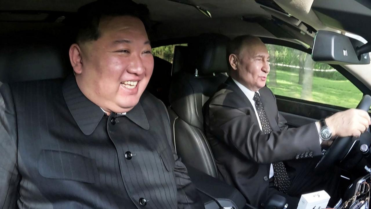 Russia's President Vladimir Putin, right, drives a car with North Korean leader Kim Jong Un sitting in front passenger seat