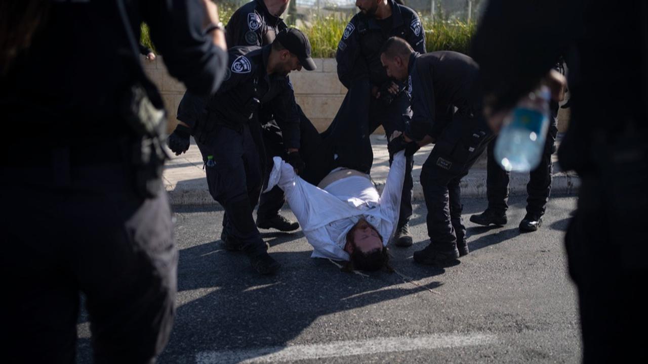  Israeli police officers remove an ultra-Orthodox Jewish man from the street during a protest