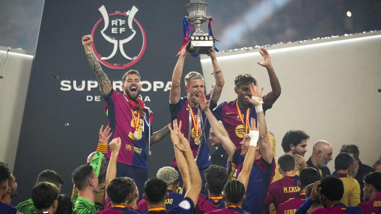 Barcelona players lift the trophy.